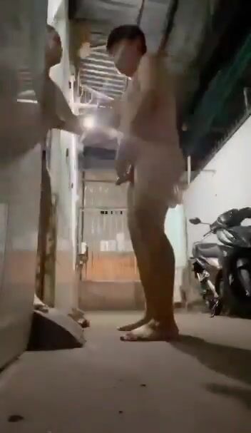 Ông chủ trọ và em sinh viên ra hành lang nhà trọ thanh toán tiền phòng.